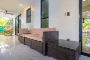 Ocean view condo patio with wicker sofa and coffee table in tropical setting.