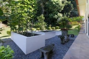 Lush tropical garden with benches and white planter in Dominical, Costa Rica.