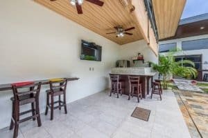 Turnkey Costa Rica villa outdoor bar with seating and ceiling fans.
