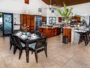 Open-concept kitchen and dining space with tropical decor and modern appliances.
