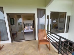 Balcony with wooden chair overlooking ocean view at Costa Rica luxury home.