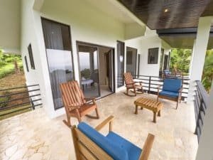 Spacious balcony with wooden chairs and ocean view in Dominical, Costa Rica.