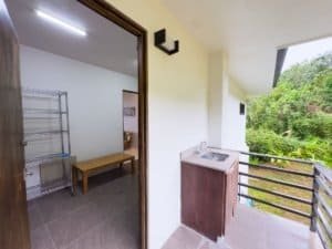 Balcony with ocean view, lush greenery, and small sink in Dominical.