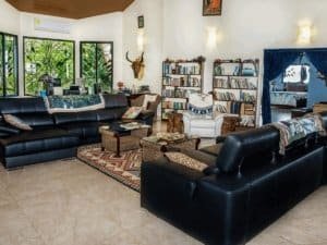 Spacious living room with ocean view, bookshelves, and tropical decor in Dominical.