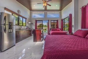 Spacious Dominical villa with red bedspreads and open-plan kitchen.