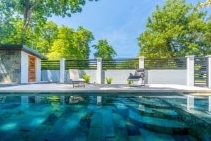 Dominical real estate pool with lounge chairs and lush trees.