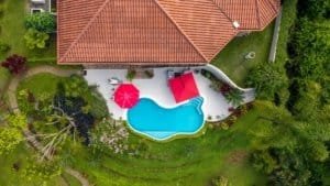 Aerial view of a luxury home with a swimming pool and lush garden in Dominical.