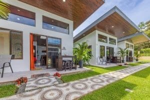 Modern Costa Rica villa exterior in Dominical with outdoor seating and palm plants.