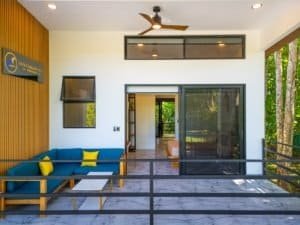 Dominical condo with blue seating and glass doors to ocean view.