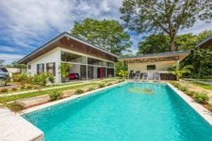 Modern single-story villa with a bright pool and outdoor seating in Costa Rica.