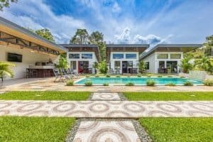 Luxurious single-story villas with a central pool and manicured lawn in Dominical, Costa Rica.