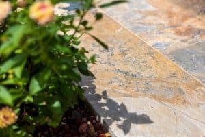 Exterior stone patio with greenery and shadows in Costa Rica property.