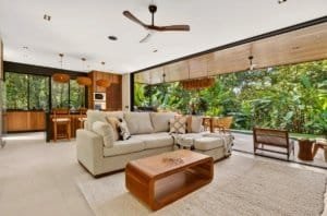 Spacious living area with cream sofa, wooden coffee table, and ample natural light.