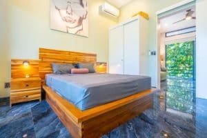 Condo bedroom with wooden platform bed and modern decor in Dominical Costa Rica.