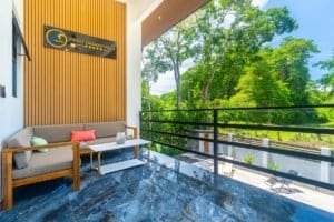 Dominical condo balcony with seating and lush green landscape view.