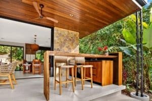 Dominical real estate: luxury jungle home with outdoor bar, natural stone, and lush tropical plants.