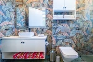 Ocean-view condo bathroom with tropical wallpaper and modern fixtures.