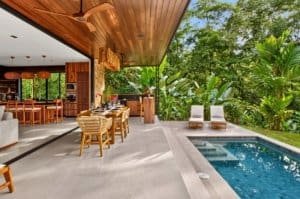 Outdoor living area with pool, seating and lush Costa Rica jungle surroundings.