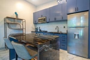 Ocean view condo kitchen with blue cabinets and marble island in Costa Rica.
