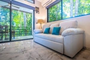 Ocean-view condo living room with large glass doors and marble floor.