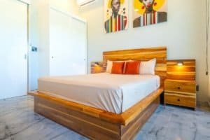 Condo style bedroom with wooden bed frame and nightstands in Costa Rica.