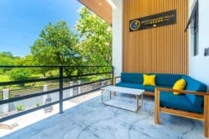 Ocean view balcony of condo with blue seating and yellow cushions in Costa Rica.