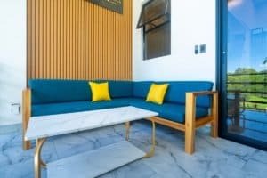 Dominical Real Estate stylish blue sofa with yellow cushions on marble coffee table in patio.