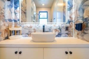 Modern bathroom vanity with vessel sink and blue floral wallpaper in Dominical Costa Rica.