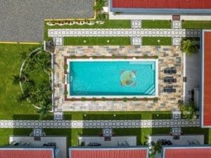 Aerial view of a rectangular swimming pool surrounded by stone patio and green lawn in Dominical, 3-.