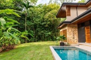 Luxurious jungle villa with swimming pool and lush green yard in Costa Rica.