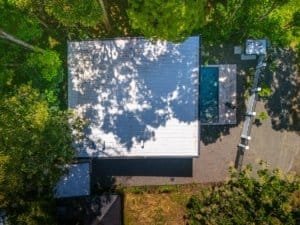 Aerial view of a modern condo with a metal roof surrounded by trees in Dominical, Costa Rica.