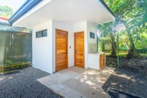 Dominical real estate: 2 bedroom ocean view condo entry with wood doors and outdoor seating.