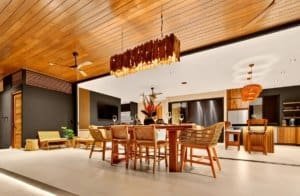 Luxurious open-concept dining area with wooden ceiling and contemporary furniture.