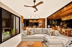 Dominical real estate interior: spacious open-concept living area with gray sectional sofa and wood.