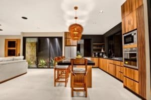 Modern Costa Rica kitchen and dining area with wood cabinets and warm lighting.