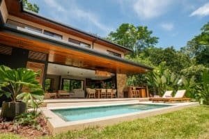 Dominical area luxury home with pool, patio and tropical landscaping.