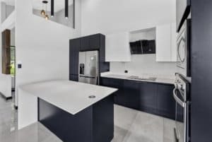Contemporary kitchen with black and white cabinetry and stainless steel appliances.