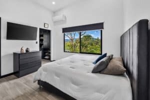 Contemporary bedroom with large window showing mountain scenery in Dominical.