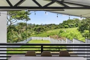Balcony view of lush green landscape and distant mountains in Dominical.