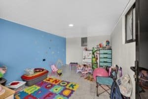 Colorful child's playroom with toys, rainbow rug, and storage in Dominical.