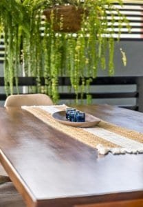 Stylish dining table with blue glass decor and hanging plants in Costa Rica.