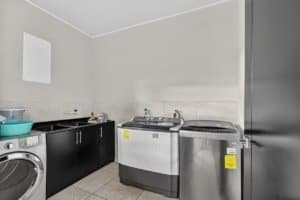 Laundry room with washer, dryer, and utility sink in Costa Rica.
