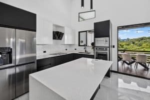 Contemporary kitchen with black and white cabinets and mountain view.