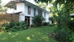 Riverfront property with guest rooms, lush garden, and trees in Dominical, Costa Rica.