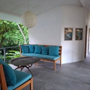 Indoor seating area with blue cushions and ocean view in Dominical, Costa Rica.