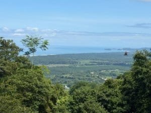 Scenic view of ocean, sunset, and lush greenery in Dominical, Costa Rica.
