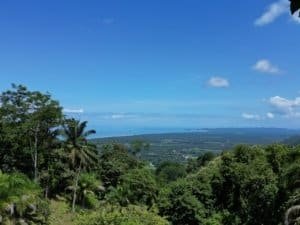 Stunning ocean and sunset views from a lush green hillside in Costa Rica.