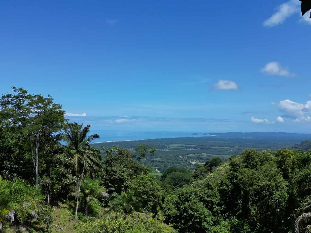 Stunning ocean and sunset views from a lush green hillside in Costa Rica.