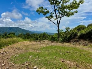 Scenic view of land with ocean and mountain backdrop in Dominical, Costa Rica.