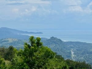Scenic view of lush green hills and ocean in Dominical, Costa Rica.